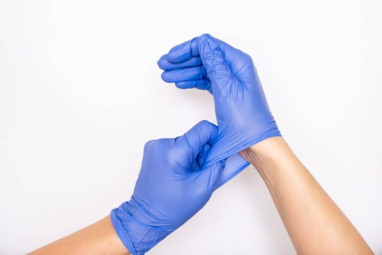 Nitrile disposable gloves being put on hand